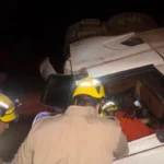 Carreta com soja tomba e motorista fica presa às ferragens